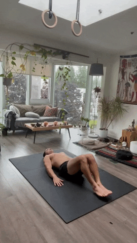 Core workouts at home: man doing reverse crunches GIF