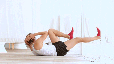 Core workouts at home: man doing bicycle crunches GIF